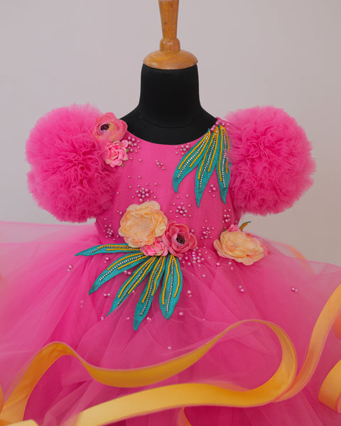 Pre-Order: Flamingo Pink Twirled Gown Embellished with Artificial Flowers  and Greenish Blue Petals