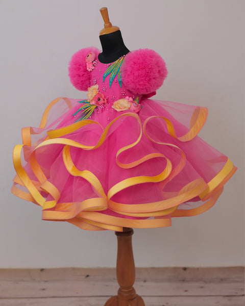 Pre-Order: Flamingo Pink Twirled Gown Embellished with Artificial Flowers  and Greenish Blue Petals